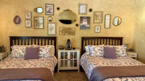 Cozy Amethyst Suite bedroom with double queen beds and rustic wall art.