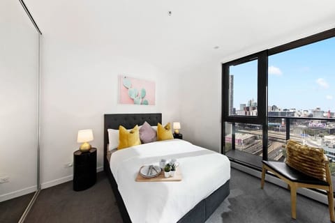 The master bedroom with a double sized bed & city views.