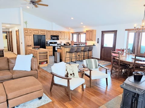 Living room, wood stove, kitchen, and dining table.