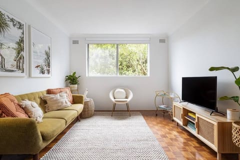 Light filled lounge room with retro sofa, smart TV, and free wifi