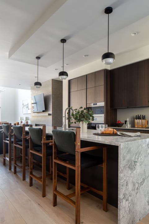 Your gourmet kitchen awaits with sleek marble countertops, modern pendant lighting, and a spacious island perfect for morning coffee or evening wine with friends