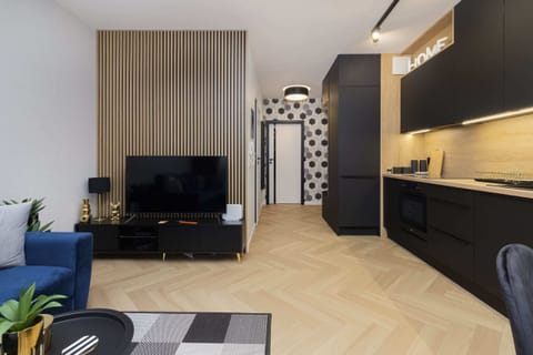 Another angle of the living room showcasing a TV unit, wooden flooring, and modern furniture arranged in a neat layout.