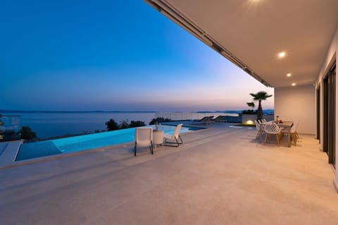 The gigantic pool terrace with large, covered, outdoor dining area for 10. At night the sparkling lights of the stars and the historic downtown of Split wink at you.