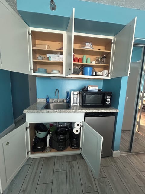 fully stocked kitchenette with airfryer, crockpot, dishes, coffee makers