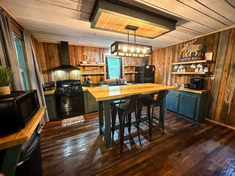 High-top dining table with seating for 4, conveniently located by the kitchen.