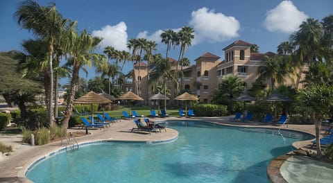 Unwind poolside beneath palms with calm, warm waters.