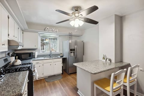 Prep meals in the large kitchen with granite countertops, refrigerator, microwave, and cozy eat-in space.