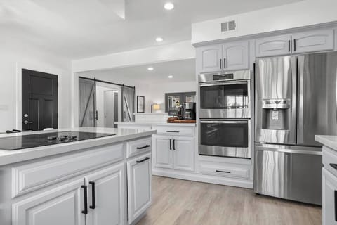 Modern kitchen with stainless steel appliances and a spacious island for cooking.