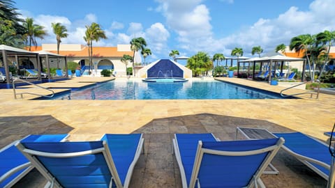 Stretch out on loungers facing a dazzling, palm-framed pool.