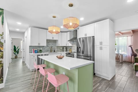 The brand-new chef’s kitchen is fully stocked with all of your cooking necessities and includes an island countertop, with 4 candy colored European bar stools.