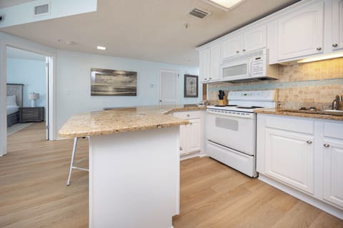 Prepare meals in this spacious kitchen, enjoying the warm tones and inviting layout that enhances your stay