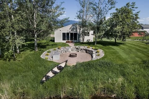 Back entry to the home with family fire pit and canoe to enjoy spring fed creek.