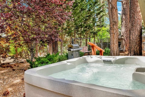Private outdoor hot tub, surrounded by tall pines, perfect for relaxing under the trees after a day of adventure—enjoy peaceful forest views, fresh air, and a truly rejuvenating stay.