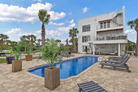 Palm-lined pool deck w/ loungers & elevated spa for laid-back days in the sun