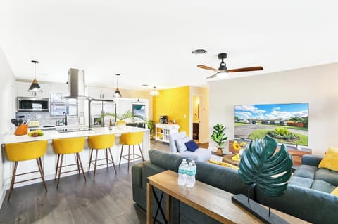 Gather with friends and family in our open concept kitchen and living room, where bright yellow accents add a pop of color to the space. 