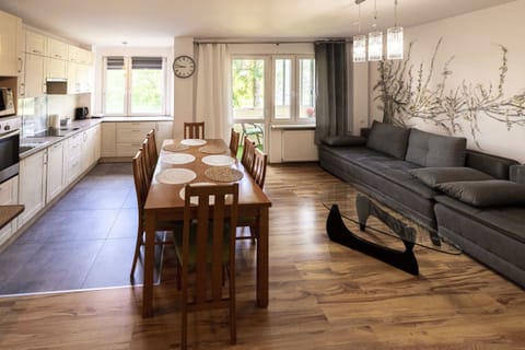 A dining area with a wooden table and chairs, extending into the living room.
