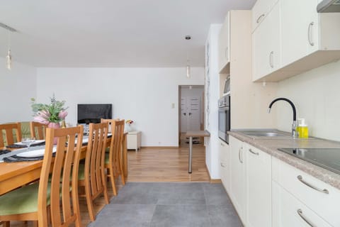 A view of the kitchen and dining area with ample seating and white cabinets.
