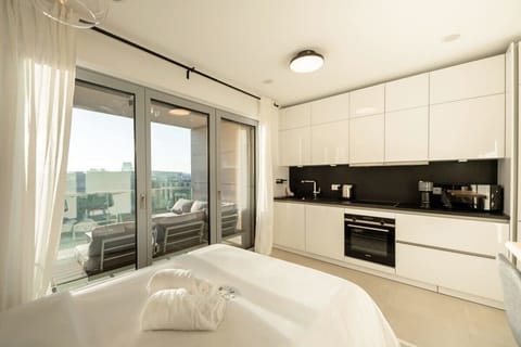 Serene bedroom with direct access to a private balcony, blurring the lines between indoors and out.