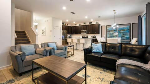 Spacious open-concept home with modern decor, cozy seating, and a full kitchen.