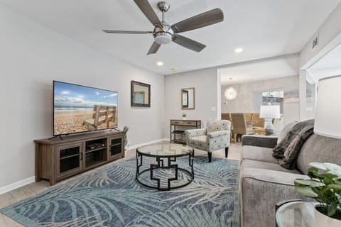 Open living room with 65" Smart TV, pull out couch, overlooking the pool area.