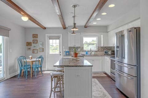 - Bright white kitchen features granite countertops, stainless steel appliances
- Center island includes barstool seating for casual bites or conversation
- Small café table by the door is perfect for coffee or breakfast