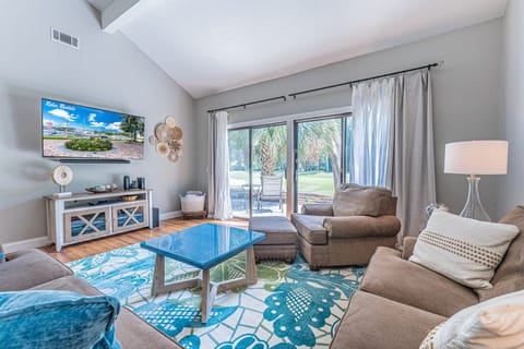 Beautifully furnished and spacious living area with a queen-size sleeper sofa, flat-screen Smart TV, and access to the patio with a golf course view.