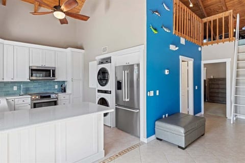 Airy elegance: Open-concept living, kitchen, and dining area beneath soaring ceilings.