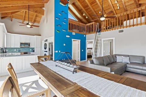 Airy elegance: Open-concept living, kitchen, and dining area beneath soaring ceilings.