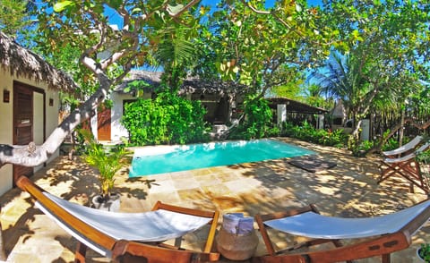 6x3m pool with large pool deck with 4 pool chairs and 2 fatboys set up garden.