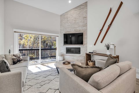 Living room: Couch, 2 chairs, gas fireplace, 70” TV, access to balcony