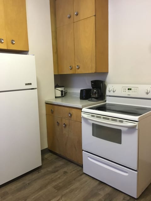 Full kitchen with vintage cabinets and fixtures.