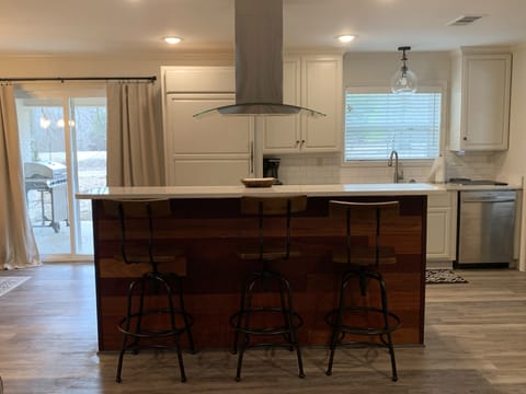 Kitchen with glass sliding door access to back patio with gas grill 