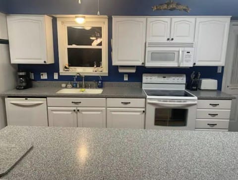 Large kitchen with an island that is fully stocked.