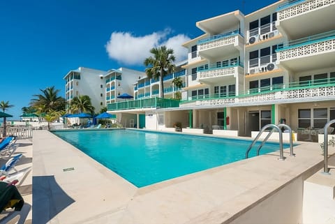 Dive into a sparkling oceanfront pool under sunny skies.