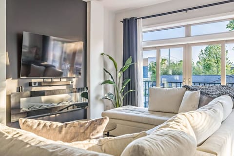 Living room boasts a 65` Smart TV, Hi-fi soundbar with sub, electric fireplace, monster sofa couch with huge pull-out sleeper