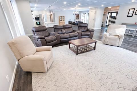 Living room with 6 recliners & Smart TV.