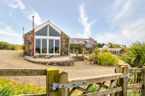 Living room Cathedral window with river pebble terrace. Gate to paddock.