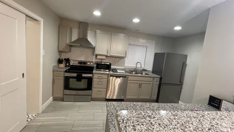 Kitchen with essential appliances and utensils to include waffle maker
