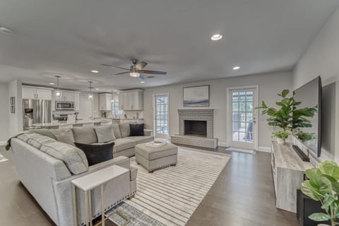 Living room with large Smart TV, fireplace and air hockey table.
