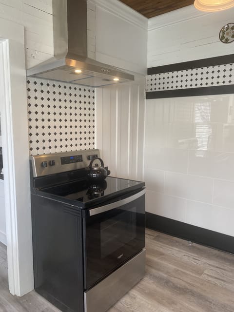 Glass top electric stove with hood vent.