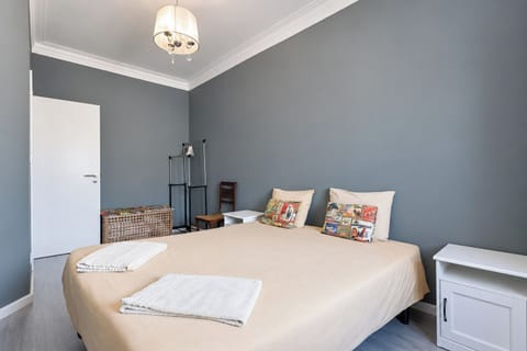 Bright double bedroom with a comfortable bed, bedside table and peaceful grey décor.