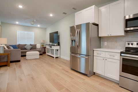 Kitchen and living room- brand new sectional couch. 65 in Samsung TV.