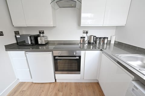 Fully equipped kitchen with fridge, hob, oven, washing machine.