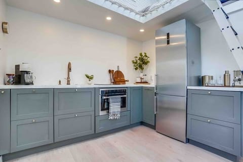 From left to right we have, a Nespresso Maker,  hidden Dishwasher (first set of drawers), stove top, combination microwave/oven, French press station, refrigerator with ice maker, and little bar area. 