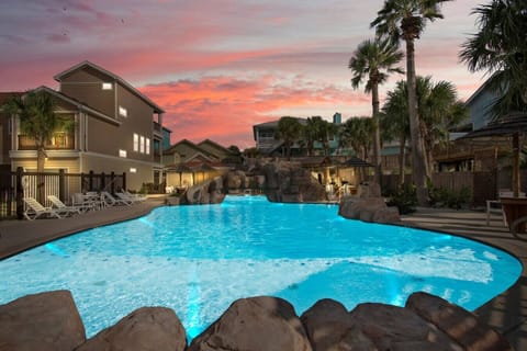 Resort-style pool glowing at sunset.