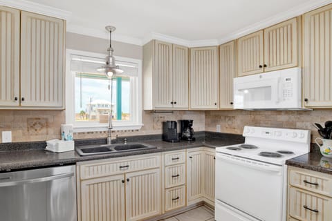 The kitchen is fully equipped and has stone counters
