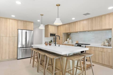 Modern kitchen with a large island and natural wood cabinetry for a warm, inviting atmosphere.