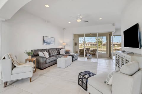 The comfortably furnished living area is highlighted by a wall of sliding doors overlooking the outdoor living space.