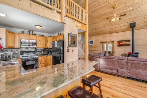 Granite countertops lead into a spacious lounge with high ceilings and soft lighting