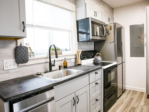 Kitchen - A photo showing the kitchen amenities such as: dishwasher, sink, oven, microwave, and refrigerator.